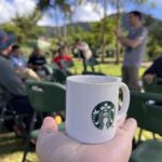 उत्तरी इंडोनेशिया में स्टारबक्स के साथ कप करने के लिए बीन, पृष्ठभूमि में सक्रिय माउंट सिनाबुंग के साथ